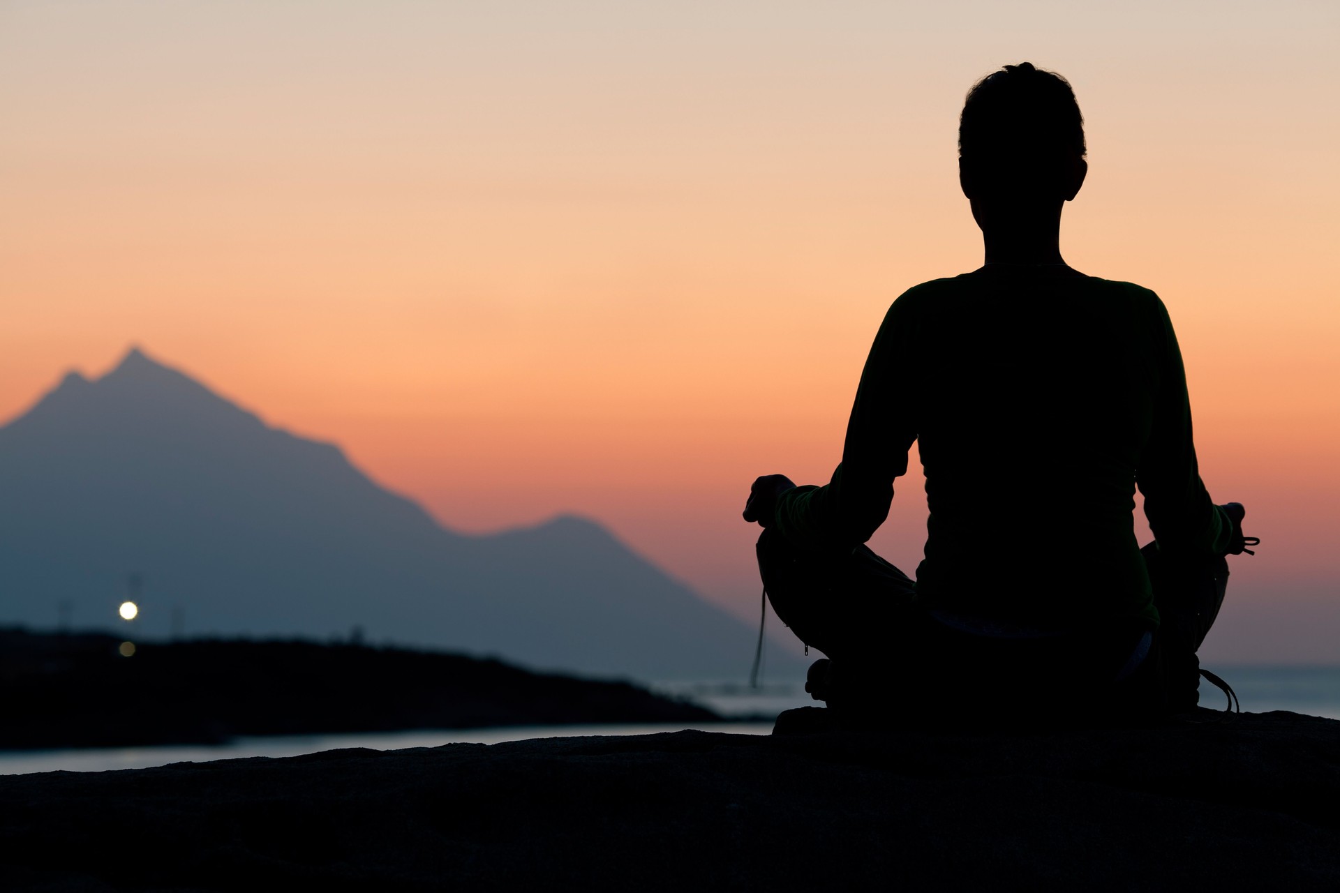 Woman meditating on sunrise